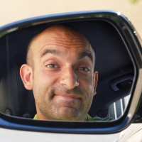 Spiegelbild des Kuenstlers im Auto im Rueckspiegel