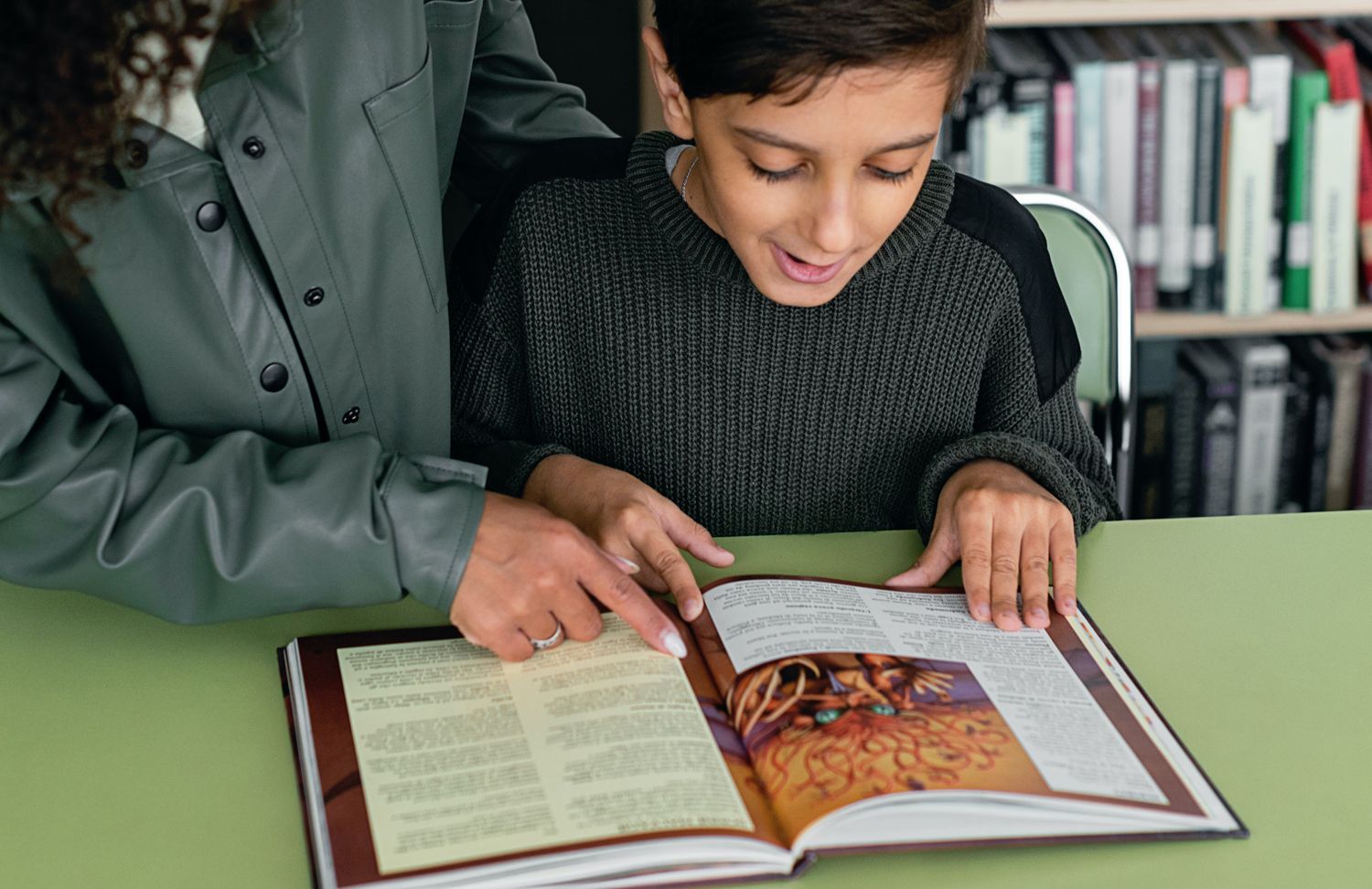 Erwachsener und Kind lesen zusammen in einem Buch