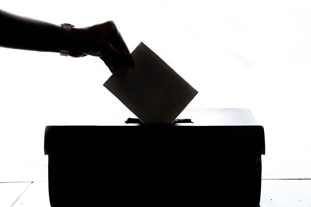 Bild: Hand wirft Wahlbrief in Wahlurne