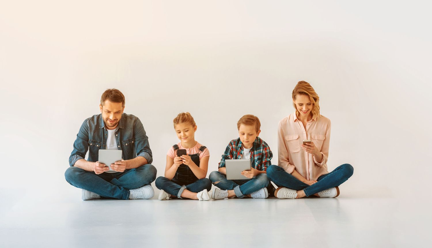 Vierkoepfige Familie mit digitalen Medien